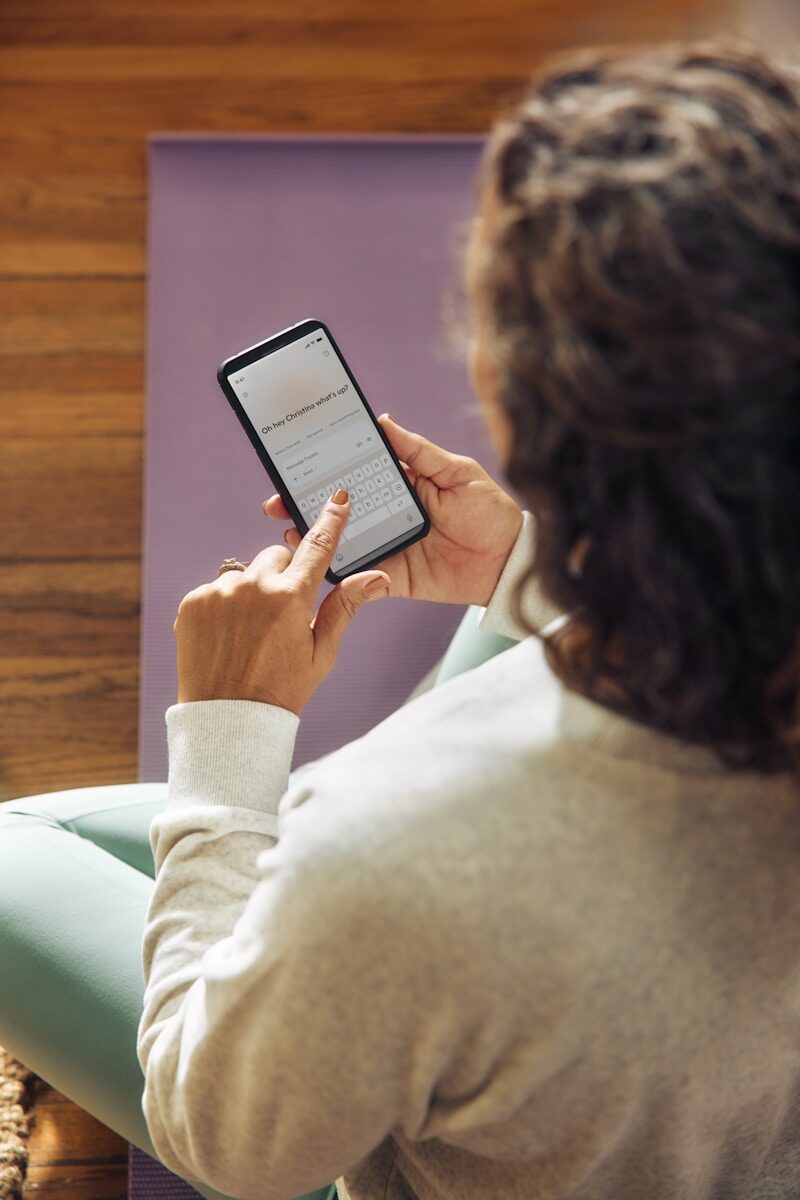 Woman using a smartphone on a yoga mat