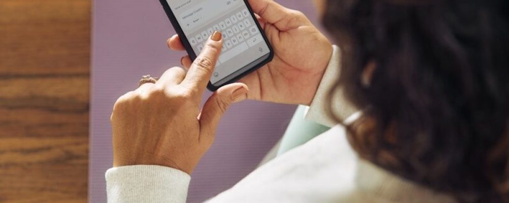 Woman using a smartphone on a yoga mat